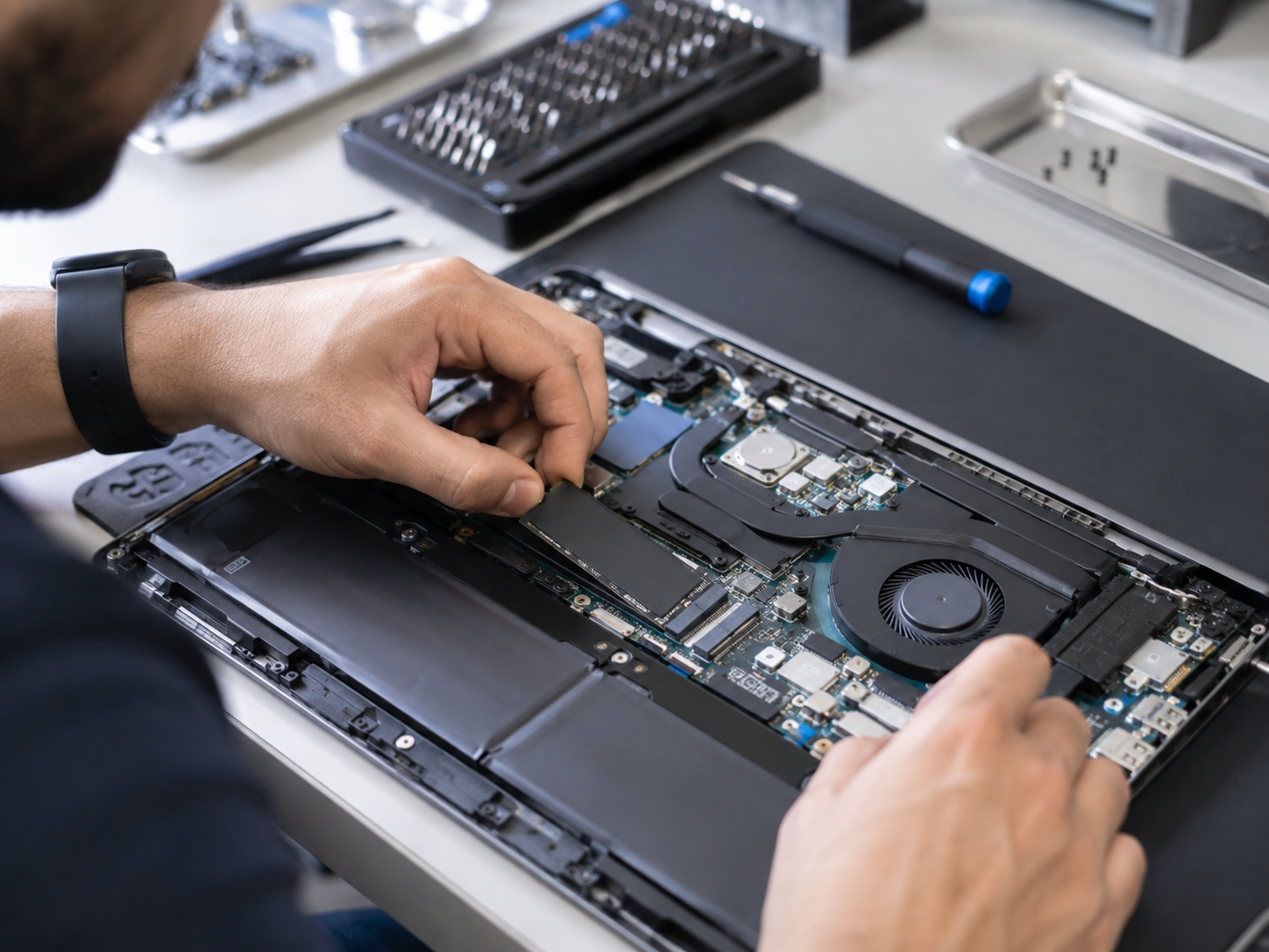 Technician upgrading SSD or other internal laptop hardware